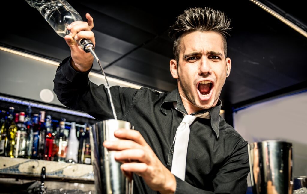 Photo of bartender free pouring a drink