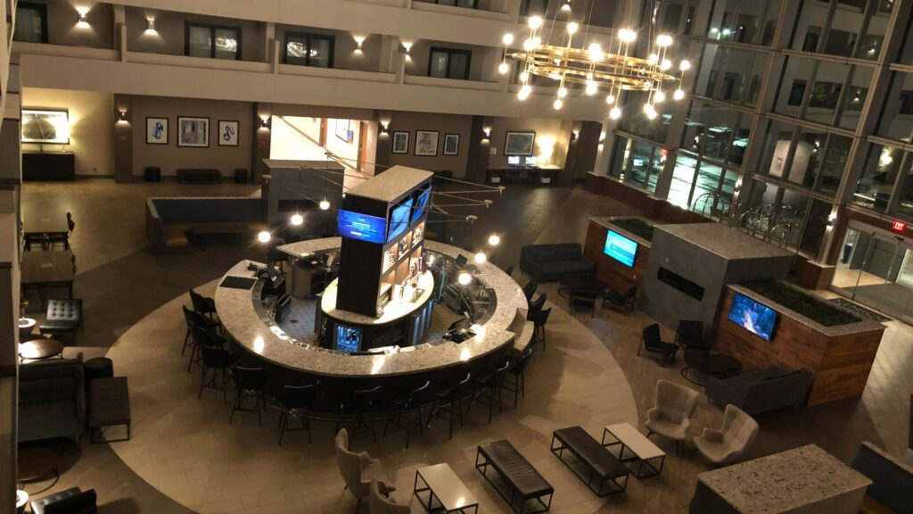 Architectural bar design in a hotel atrium with circular bar layout, ambient lighting, and strategic seating — showcasing commercial bar architecture and guest experience planning